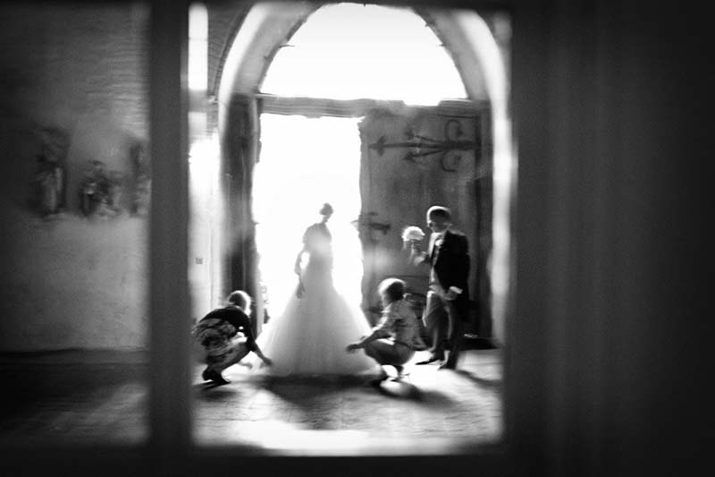 Ein Bild von der Braut und ihrem Vater vor der Trauung durch ein Fenster aufgenommen.